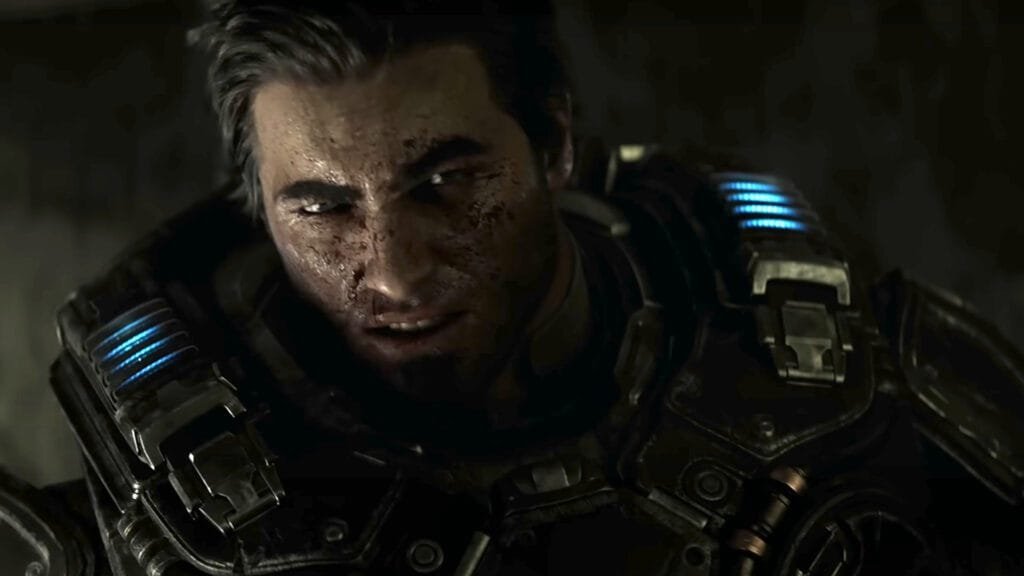 A close-up of a battle-worn male soldier with dirt and scratches on his face. He has dark hair, intense eyes, and a serious expression. He's wearing futuristic, armored combat gear with glowing blue lights on the shoulder pads. The scene is dark and gritty, suggesting a tense or war-torn environment.
